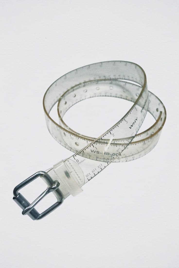 A transparent ruler belt coiled like a tape measure, with a metal buckle